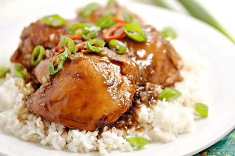 A close-up of delicious Hawaiian Shoyu Chicken served over a bed of white rice and garnished with fresh green onions.