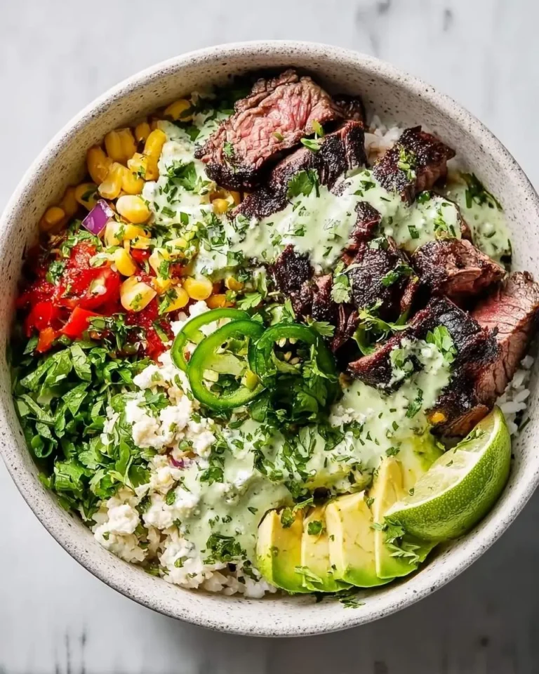 A vibrant overhead shot of delicious Cilantro lime steak bowls featuring perfectly cooked steak, rice, avocado, corn, and fresh herbs.