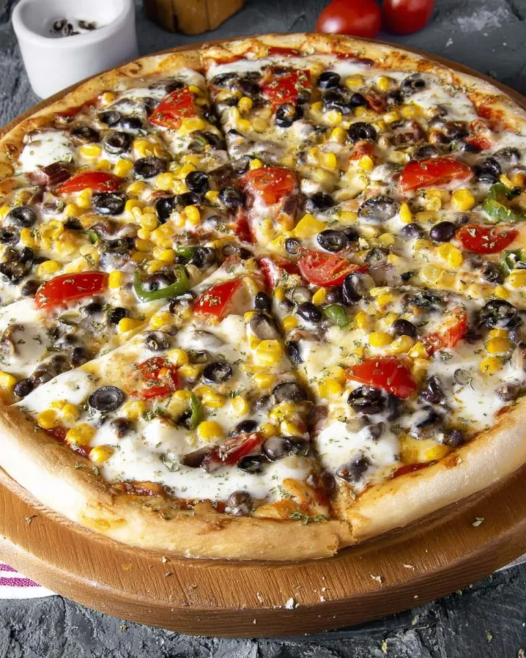 A delicious Vegetarian Black Bean Pizza, generously topped with black beans, corn, fresh tomatoes, and melted white cheese, served on a wooden board.