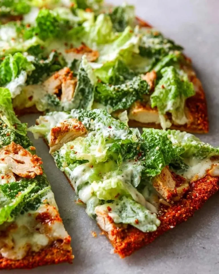 Freshly sliced Chicken Caesar Salad Pizza topped with grilled chicken, crisp romaine, parmesan, and creamy Caesar dressing.