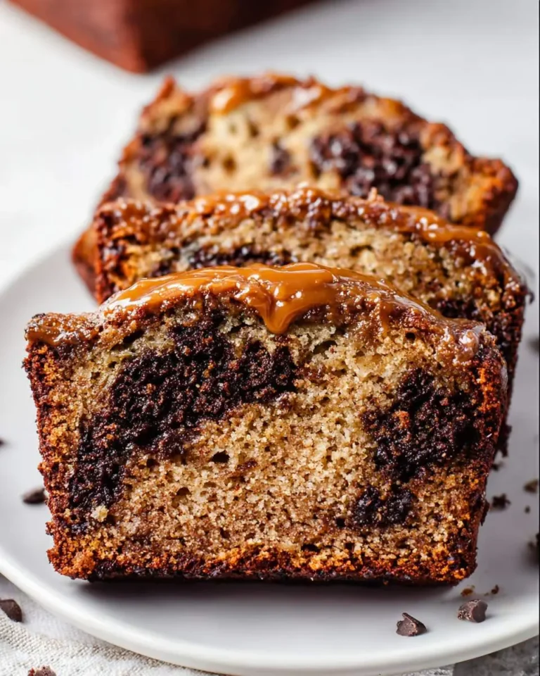 Slices of moist Chocolate Caramel Banana Bread drizzled with rich caramel sauce, showing chocolate swirls.