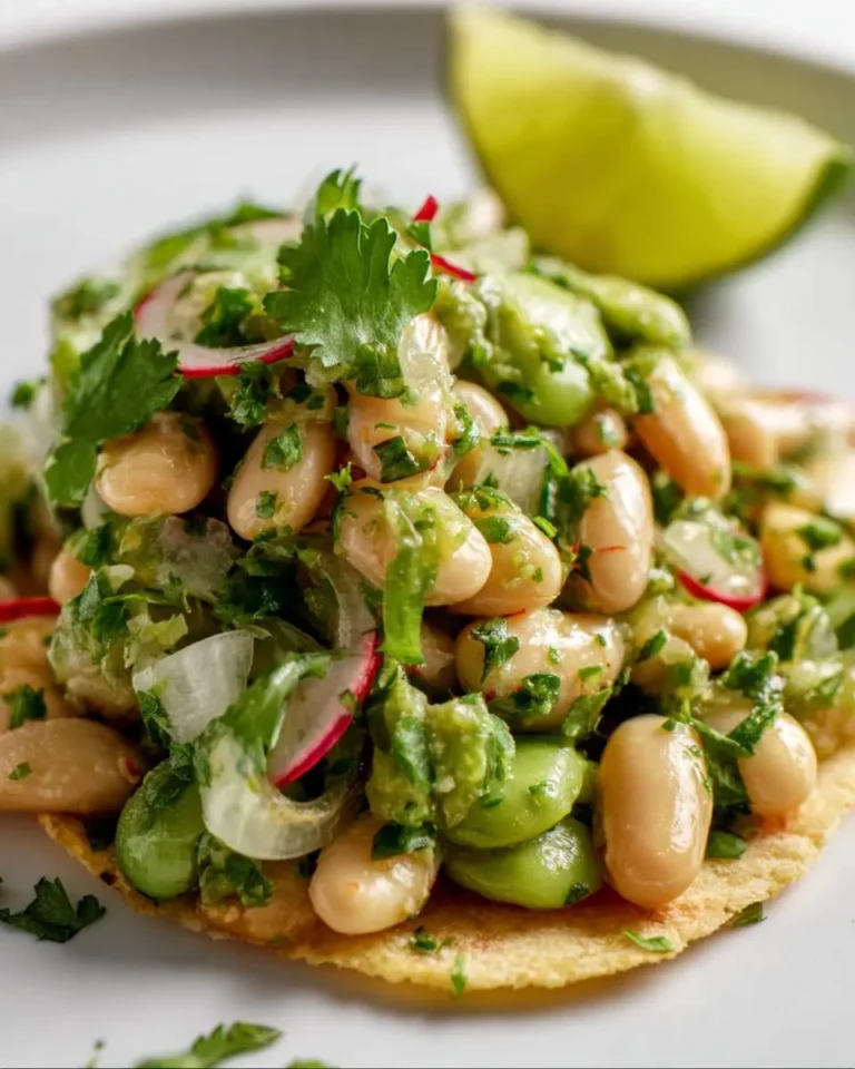 Close-up of a fresh Cilantro Lime Bean Salad featuring white and green beans, radish, and cilantro, served on a flatbread.