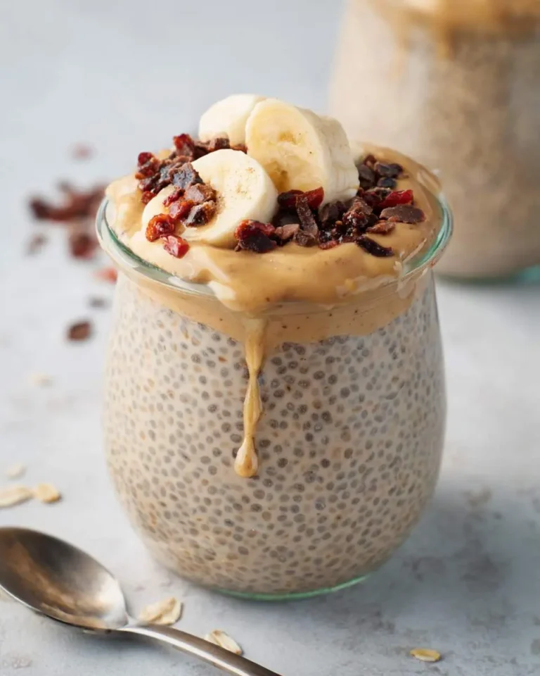 Creamy peanut butter chia pudding in a glass jar topped with banana slices and dried fruit.
