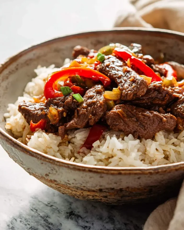 A savory Beef and Pepper Rice Bowl with tender strips of beef, red bell peppers, and green onions served over white rice in a ceramic bowl.