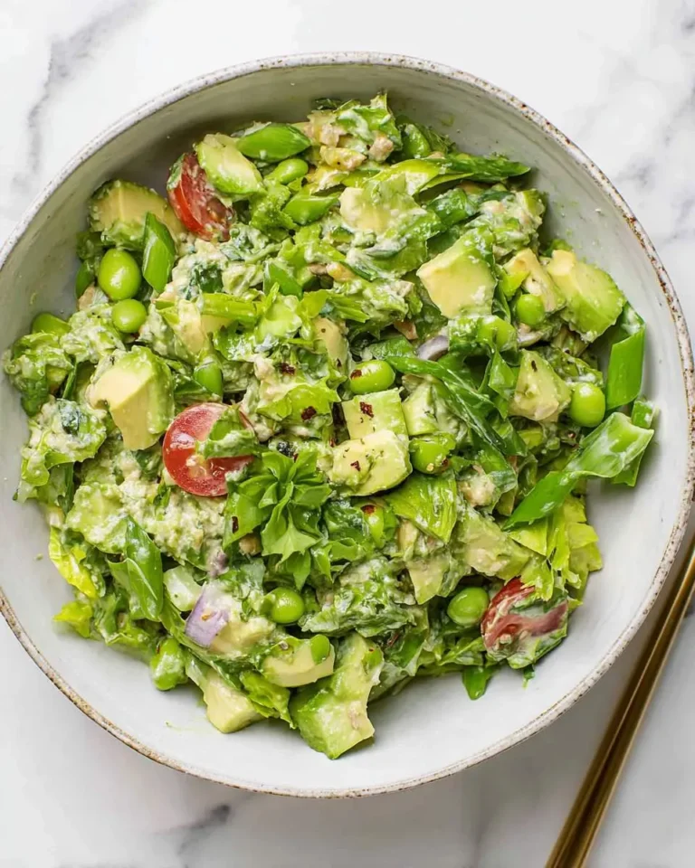 Fresh Green Goddess Avocado Salad with edamame, cherry tomatoes, and creamy herb dressing in a ceramic bowl.