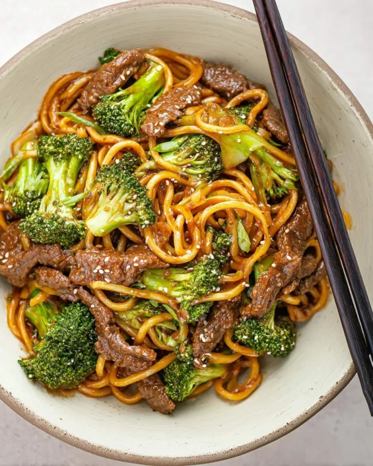 A bowl of Low-Carb Beef & Broccoli Noodles with tender beef strips, fresh broccoli, and saucy noodles topped with sesame seeds.