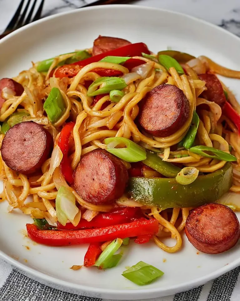 Low Carb Lo Mein With Keilbasa & Peppers served on a white plate with noodles, sliced sausage, and colorful bell peppers.