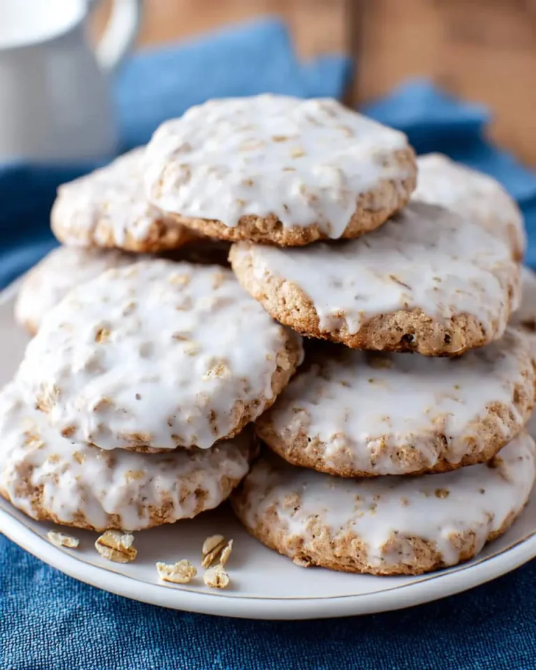 A stack of iced oatmeal cookies with white glaze on a plate, featuring the Iced Oatmeal Cookies Recipe focus.