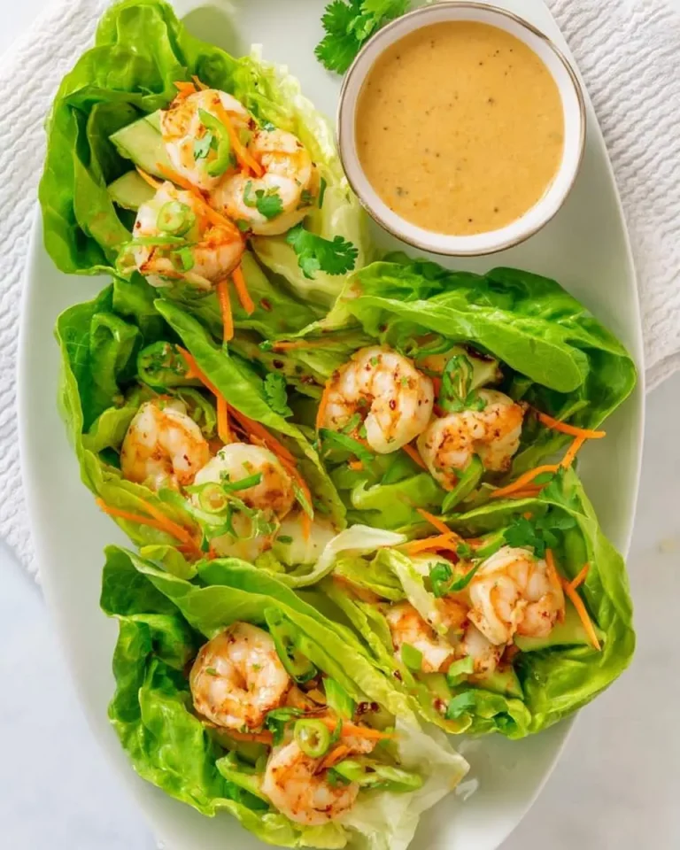Fresh Shrimp Lettuce Wraps with Peanut Sauce served on a white platter with a side bowl of creamy peanut dipping sauce.