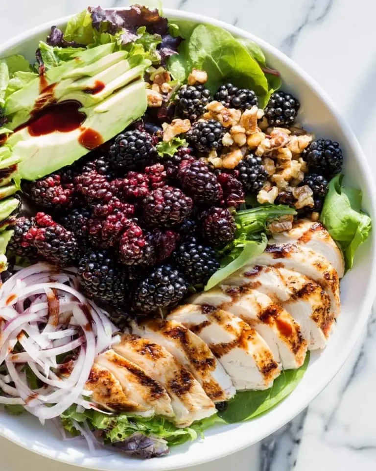 Fresh Blackberry Chicken Salad with grilled chicken, avocado, walnuts, red onion, and mixed greens in a white bowl.